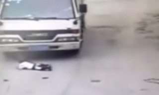  Xe tải chèn qua đứa trẻ ngồi chơi giữa đường 