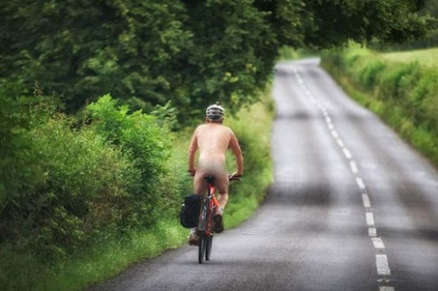 Người đàn ông đạp xe khỏa thân trong buổi sớm	